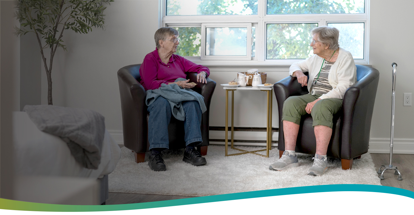 Two residents chatting together in a suite at Atrium Retirement Residence in Orillia.